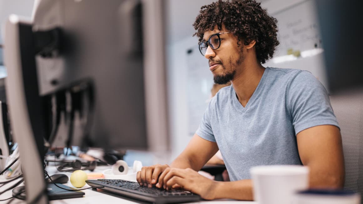 Men in a desk typing in a computer